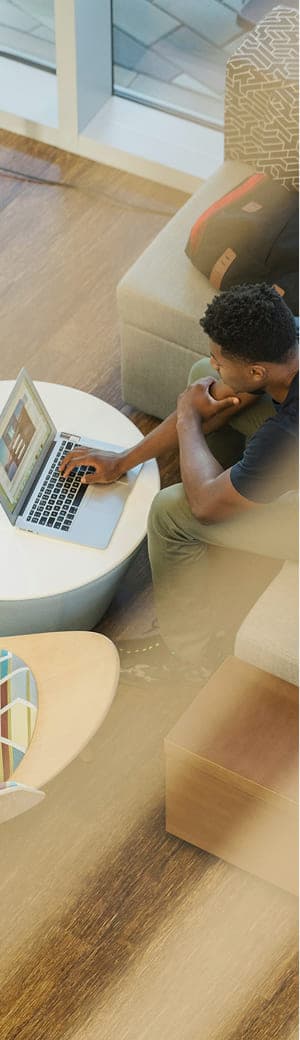 カジュアルなオフィス空間でノートパソコンで作業をする男性