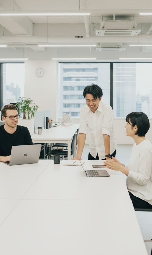 明るいオフィスで打ち合わせをする多国籍チーム