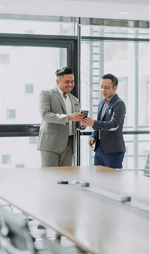 会議室で談笑する二人のビジネスマン